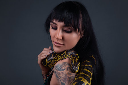 Photo of the woman with crawling yellow anaconda on neck