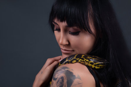 Image of the girl with yellow anaconda on shoulders and neckの写真素材