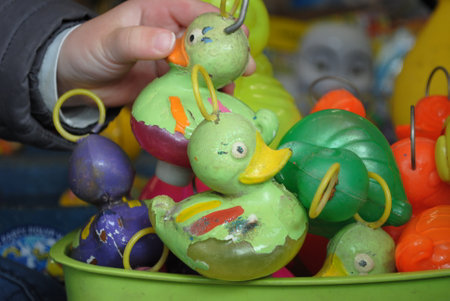 Children's hands are playing with plastic ducks in a toy store.の写真素材