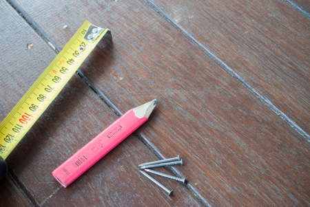 tape, pencils and nails on timber backgroundの写真素材