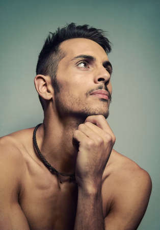 Portrait of a young man who is sitting and thinkingの写真素材