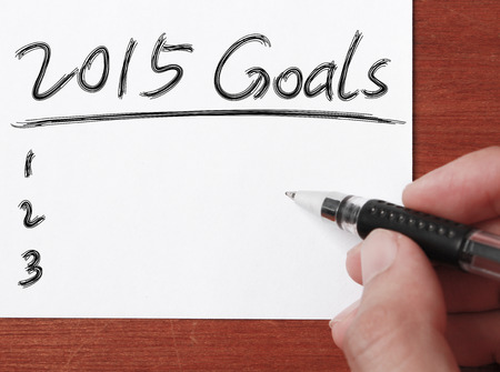 Hand with black pen is writing   2015 Goals on white paper.の写真素材