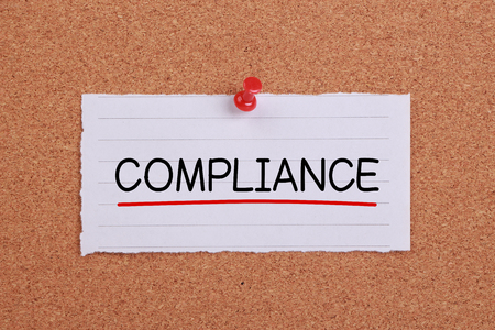 Compliance concept note paper pinned on corkboard.の写真素材