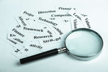 Magnifying glass and lot of other business concept words paper is showing the concept of business vision.の写真素材