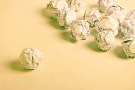White paper balls are on the white background with yellow light.の写真素材