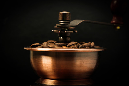 Coffee bean grinder is on the black background.