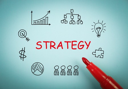 Strategy concept is on blue paper with a red marker aside.の写真素材