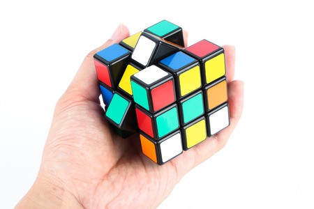 Rubik's cube is holden by hand isolated on white background.のeditorial素材