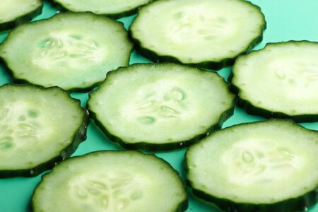 Sliced cucumber is on the green background.の写真素材
