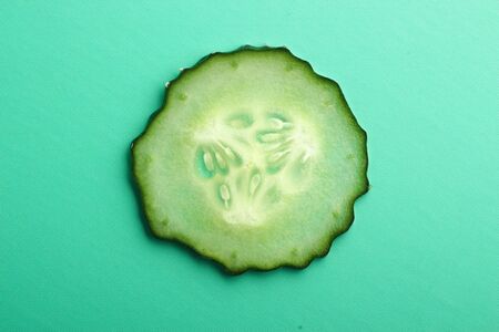 Sliced cucumber is on the green background.の写真素材