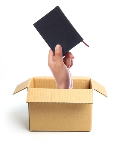 Hand with small book is out of box isolated on white.の写真素材