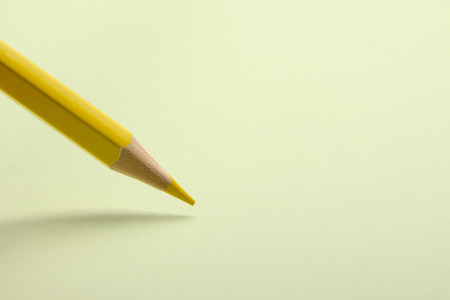 Yellow pencil is drawing on the blank background.