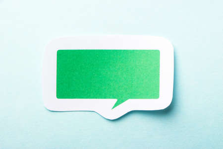 Green blank speech bubble paper on the blue background.の写真素材