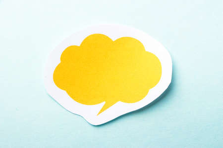 Yellow blank speech bubble paper on the blue background.の写真素材