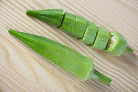 Fresh okra on the wooden table background.