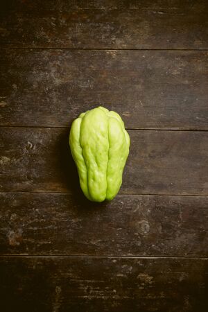 Green chayote is on the old wooden background.の写真素材