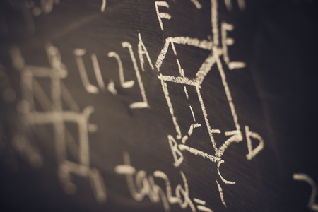 Maths formulas written by white chalk on the blackboard background.の写真素材