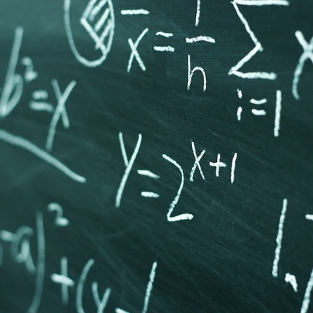 Maths formulas written by white chalk on the chalkboard background.