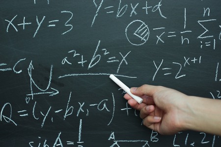 Teacher writing various high school maths formula on chalkboard.の写真素材