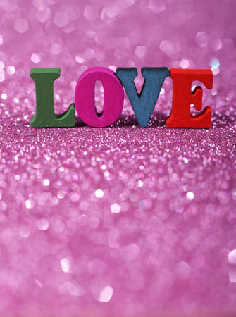 Colorful word Love with pink glittering background.の写真素材