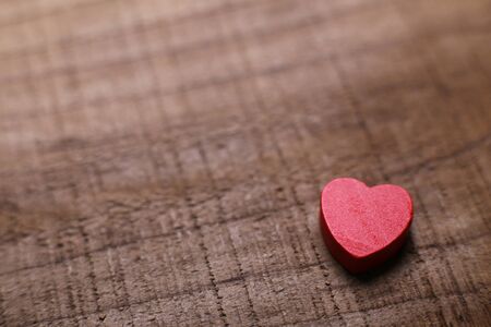 Red heart lying on the rustic wooden background.の写真素材