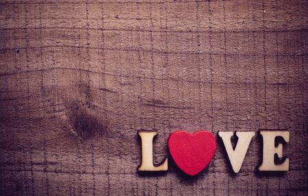 Love text with red heart lying on the rustic wooden background.の写真素材