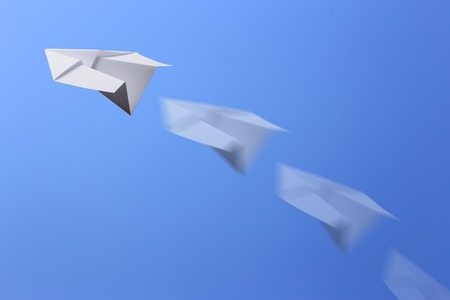 Paper plane flying in the blue sky.の写真素材
