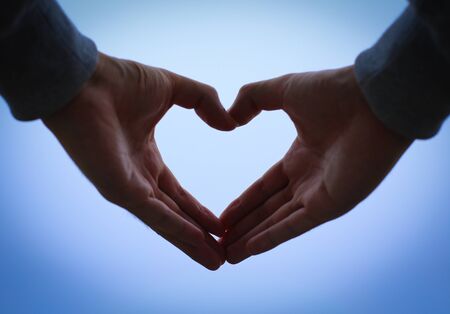 Hands in heart form love with blue sky background.の写真素材