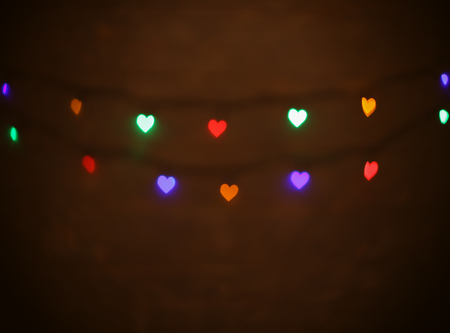 Blurred background of colorful heart shape lights on rustic wood.の写真素材
