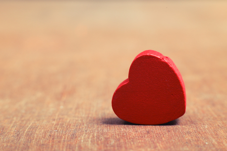 Red heart standing on the rustic wooden background.の写真素材
