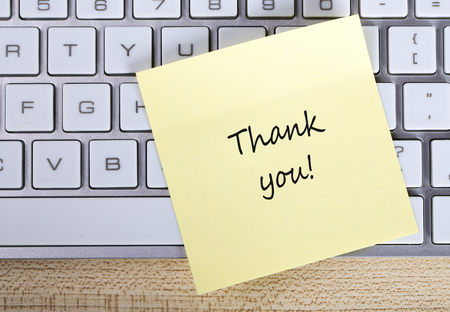 Top view of Thank You sticky note pasted on the keyboard.の写真素材
