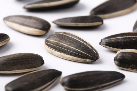 Closeup shot of sunflower seeds on white background.
