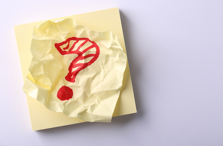 Yellow sticky note with handwritten red question mark.の写真素材