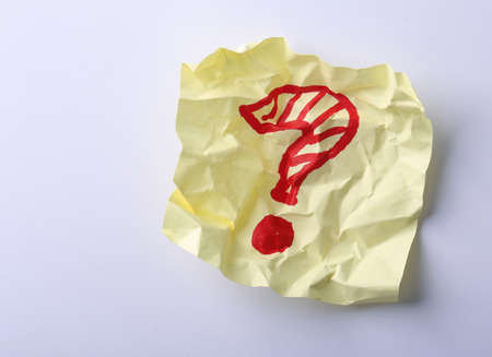 Yellow sticky note with handwritten red question mark.の写真素材