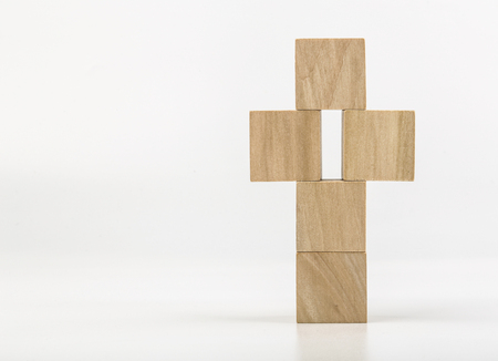 Wooden cross made of blocks is isolated on white background.の写真素材