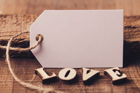 Blank white label with wooden love aside for Valentine day background.の写真素材