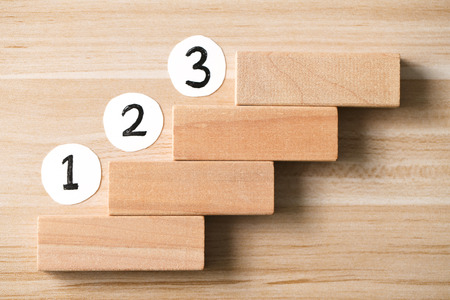 Step by step concept on the wooden desk background. Step 1, Step 2, Step 3 - the ladder to success.の写真素材