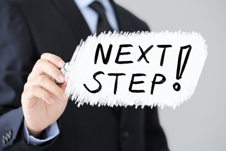 Businessman is writing the Next Step Business Concept.の写真素材