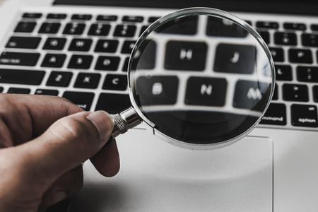 Magnifying glass with the laptop background.の写真素材