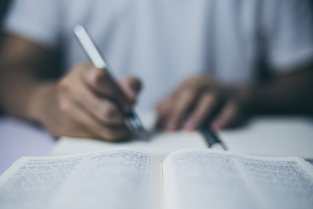 Man is taking notes with holy bible.の写真素材