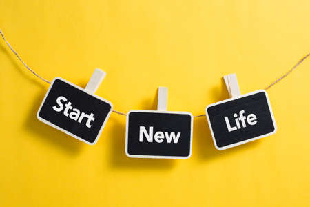 Start New Life concept small blackboard hanging on line.の写真素材