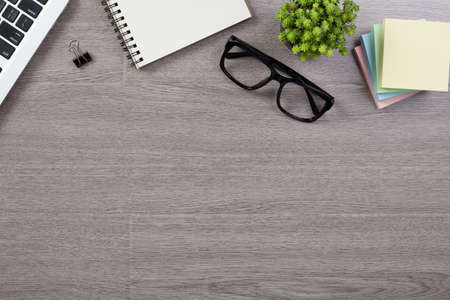 Wood office desk table top view with laptop and supplies.の写真素材