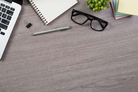 Wood office desk table top view with laptop and supplies.の写真素材