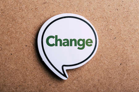 Change text concept speech bubble isolated on brown paper background with shadow.の写真素材