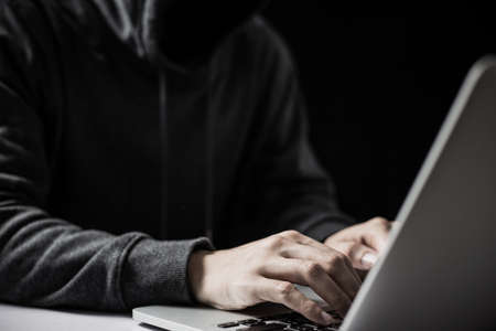 Hacker in front of the laptop computer.の写真素材