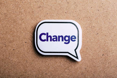 Change text concept speech bubble isolated on brown paper background with shadow.の写真素材