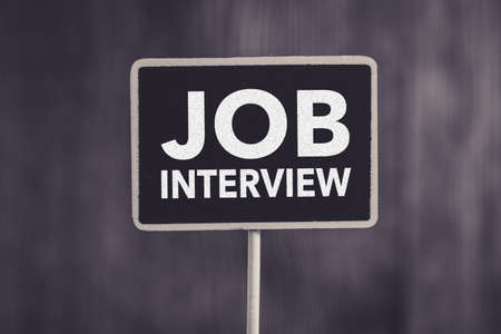 Job Interview text on blackboard sign board against wooden background.の写真素材