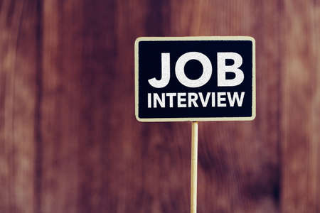 Job Interview text on blackboard sign board against wooden background.の写真素材
