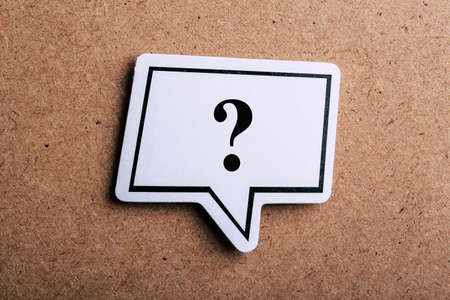 Question Mark speech bubble sign isolated on brown paper background with shadow.の写真素材