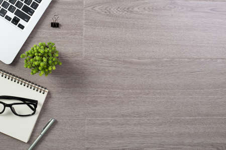 Wood office desk table top view with laptop and supplies.の写真素材